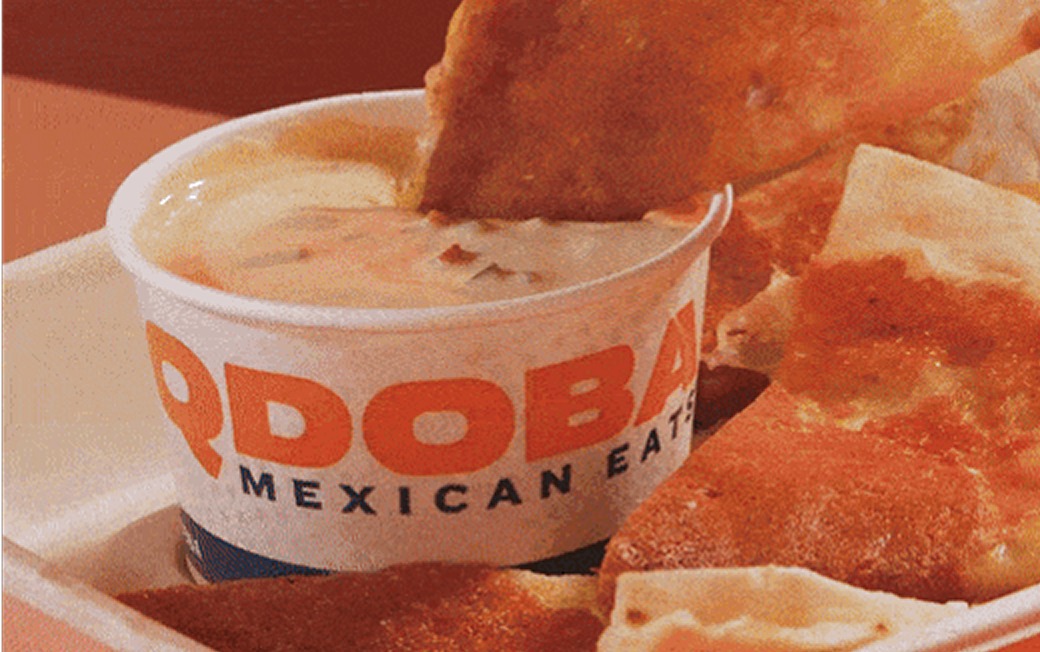 Photo of tortilla going into Qdoba queso bowl